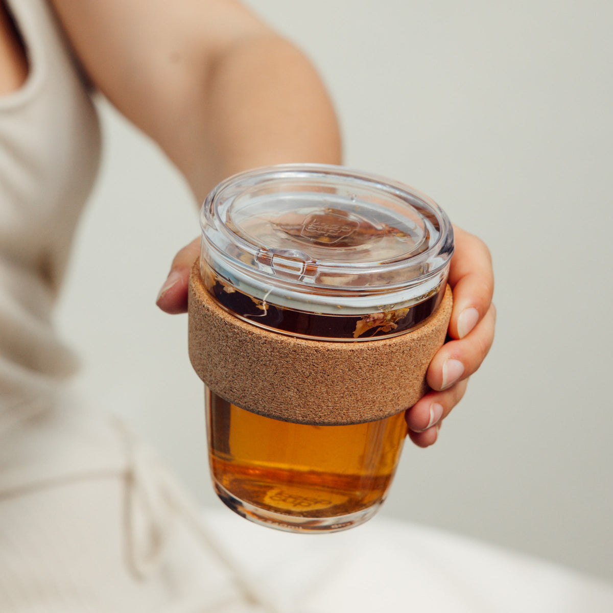 Hand holding a KeepCup Brew Cork QuickSip 340ml filled with loose leaf tea