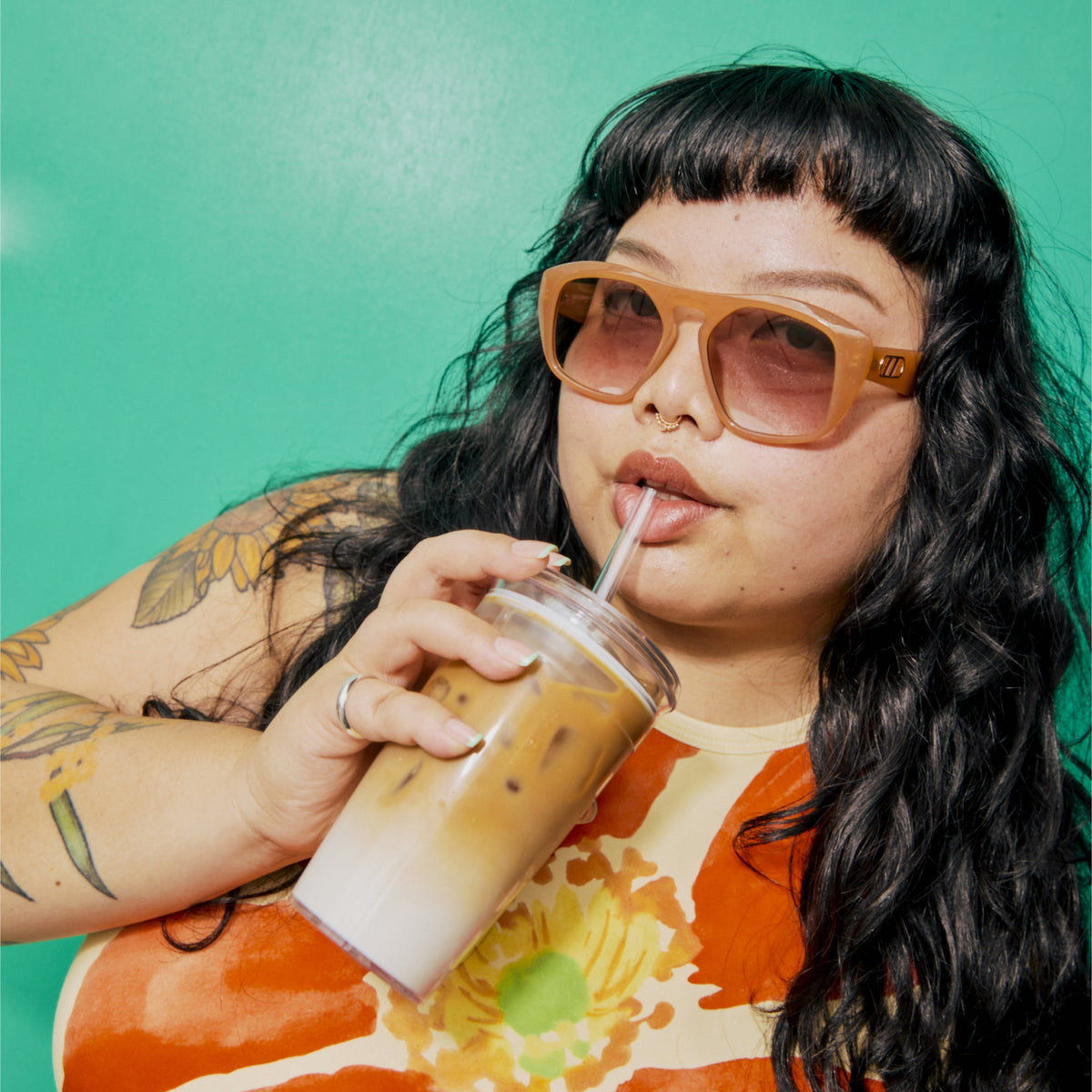 Woman sipping iced coffee from a KeepCup Cold Cup Original 454ml through the coffee straw