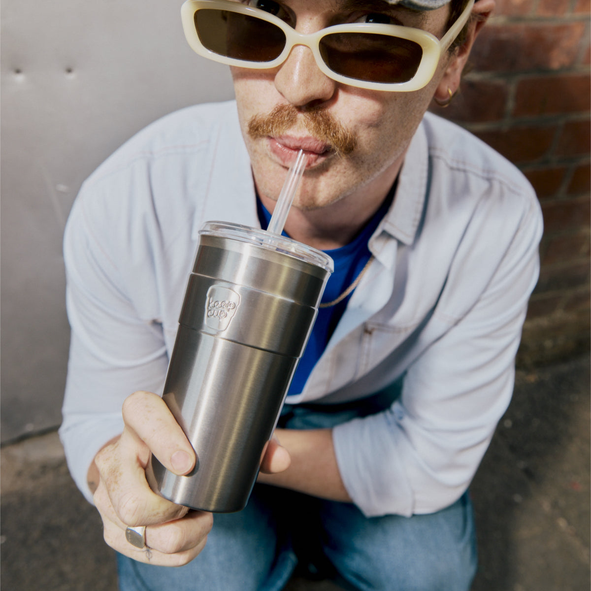 Man in yellow sunglasses sipping from a KeepCup Cold Cup Thermal 454ml in Nitro