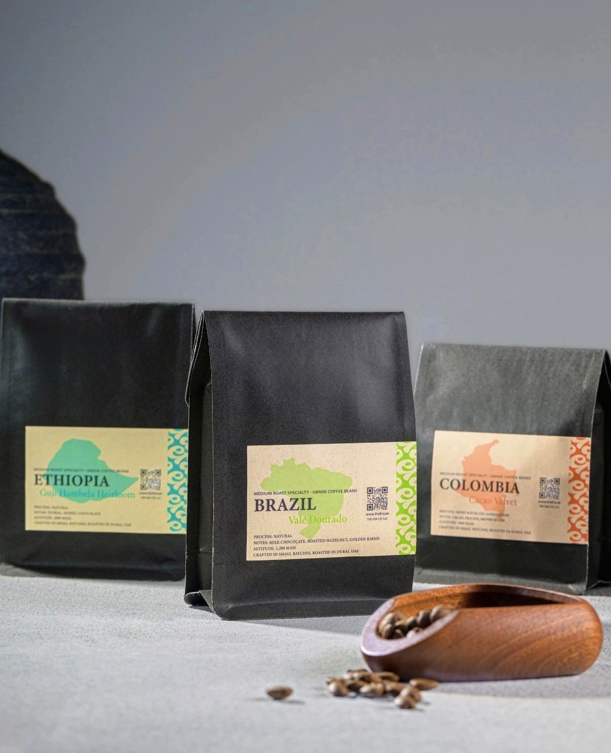 Era beans sample pack - Ethiopia, Brazil, and Colombia coffee bags with a wooden scoop of roasted beans