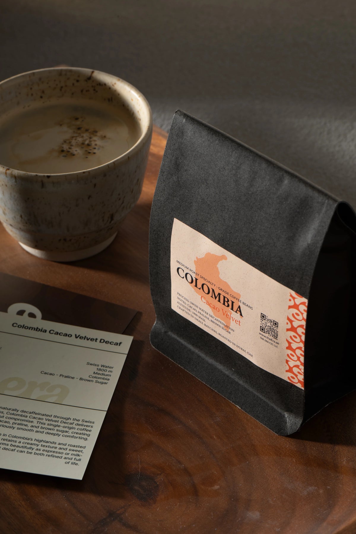 Era Colombia Cacao Velvet decaf bag with a milk-based coffee and taste note card