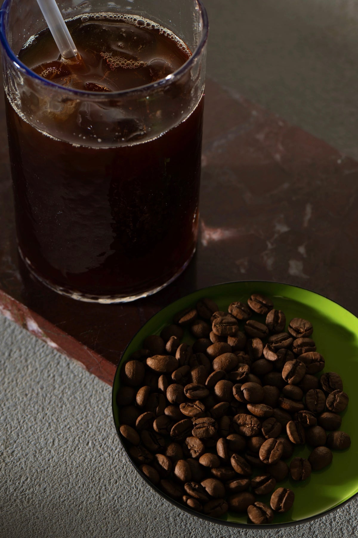 Iced Era coffee with a green plate of roasted beans