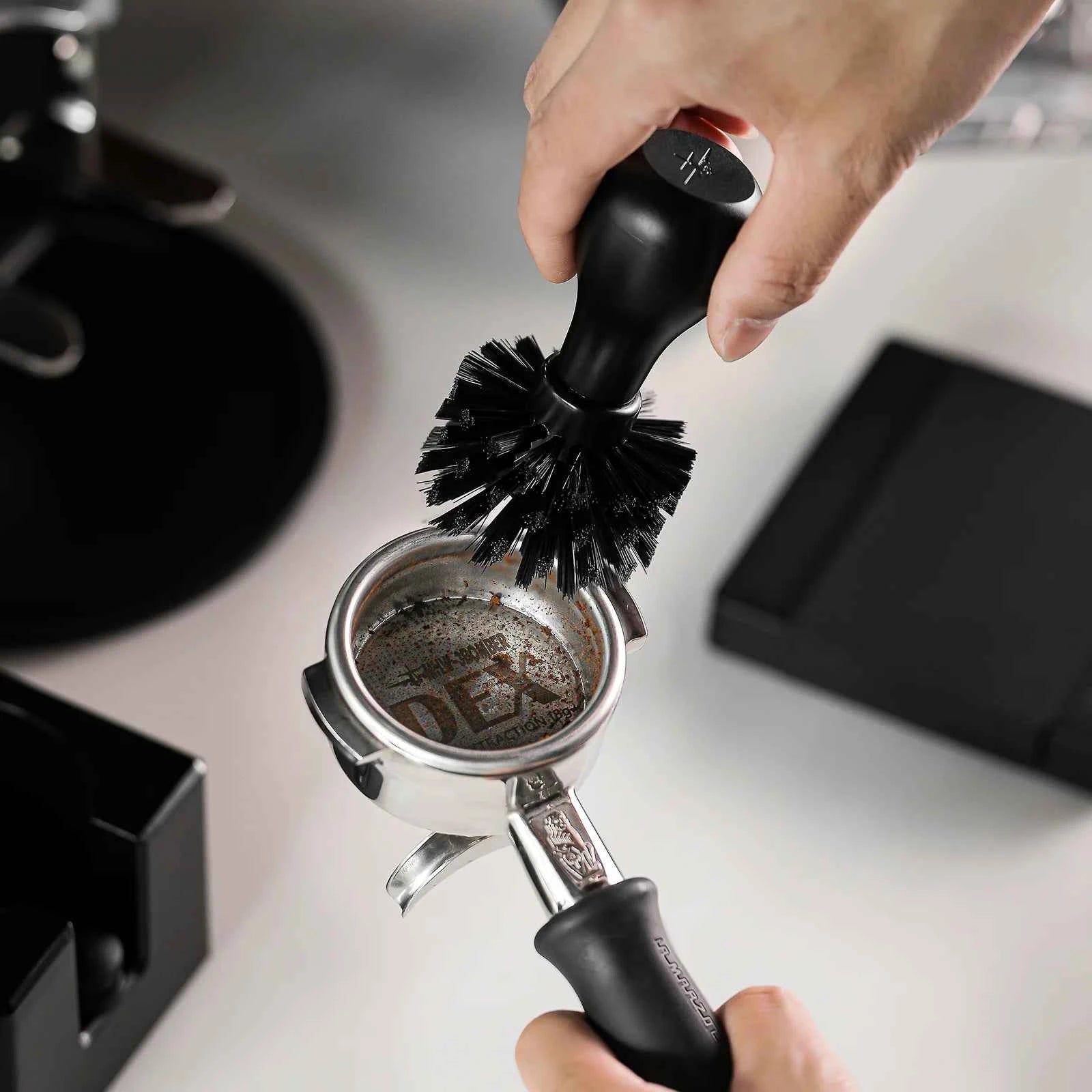 Cleaning a portafilter basket with the MHW-3BOMBER brush