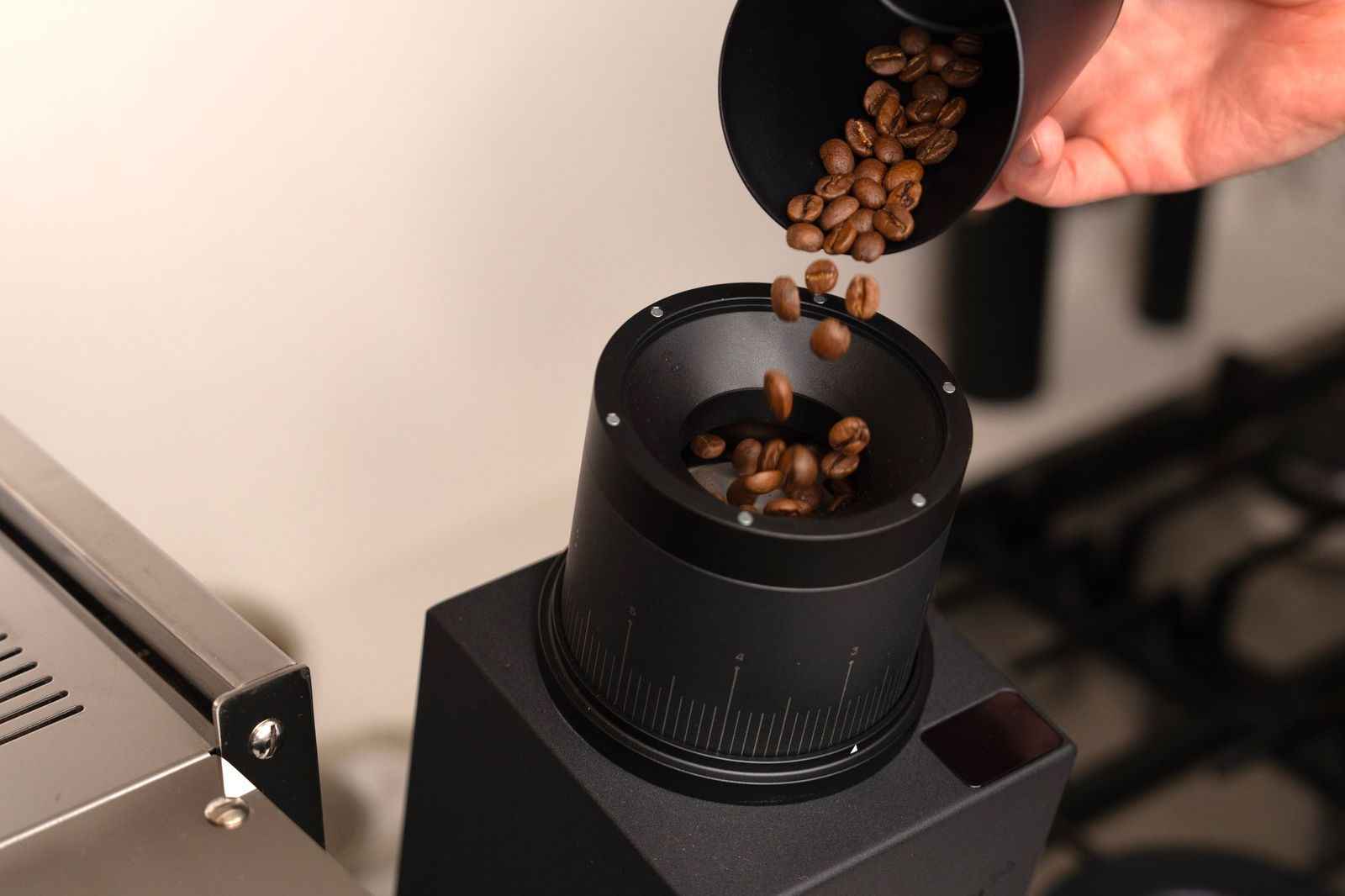 Pouring coffee beans from the Subminimal Subscale into a grinder